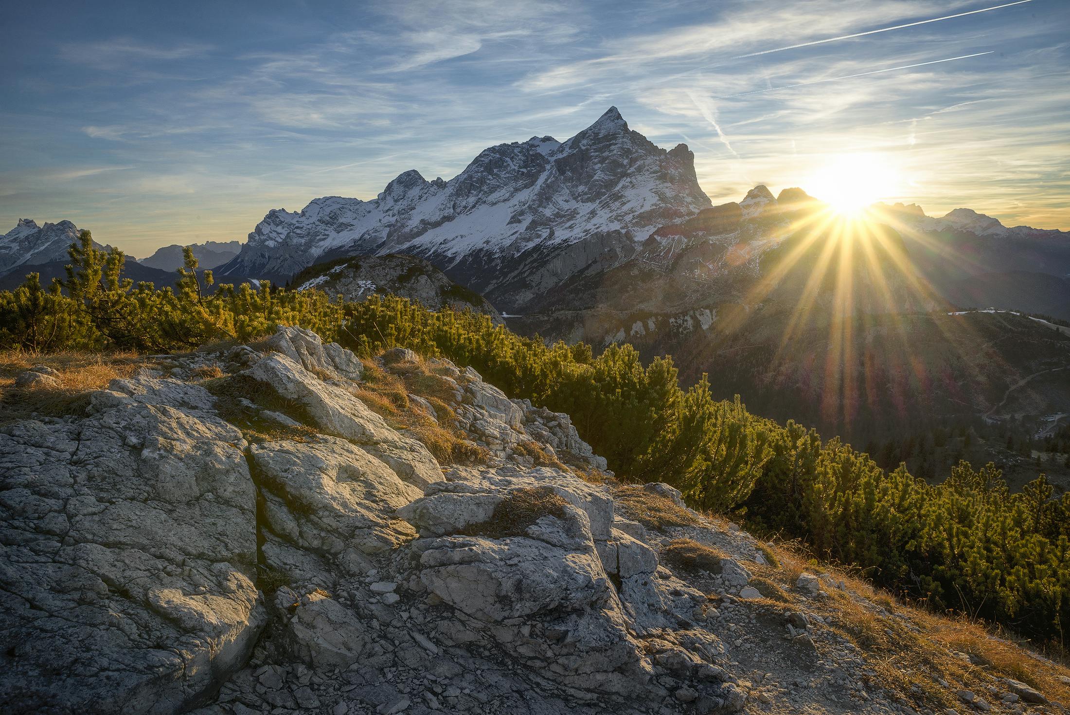 Sun rising over rocky mountain range
