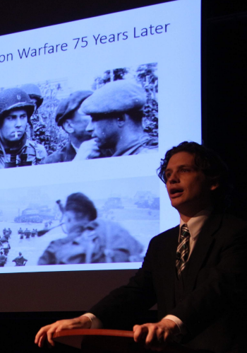 Luke Truxal in a suit giving a presentation.