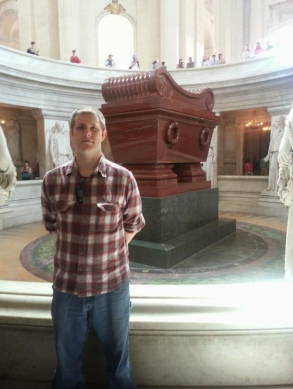 Nathaniel Jarrett in a plaid shirt in front of the tomb ofNapoleon Bonaparte.