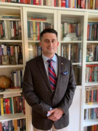 Wilson C. Blythe, Jr. standing in front of a bookcase.