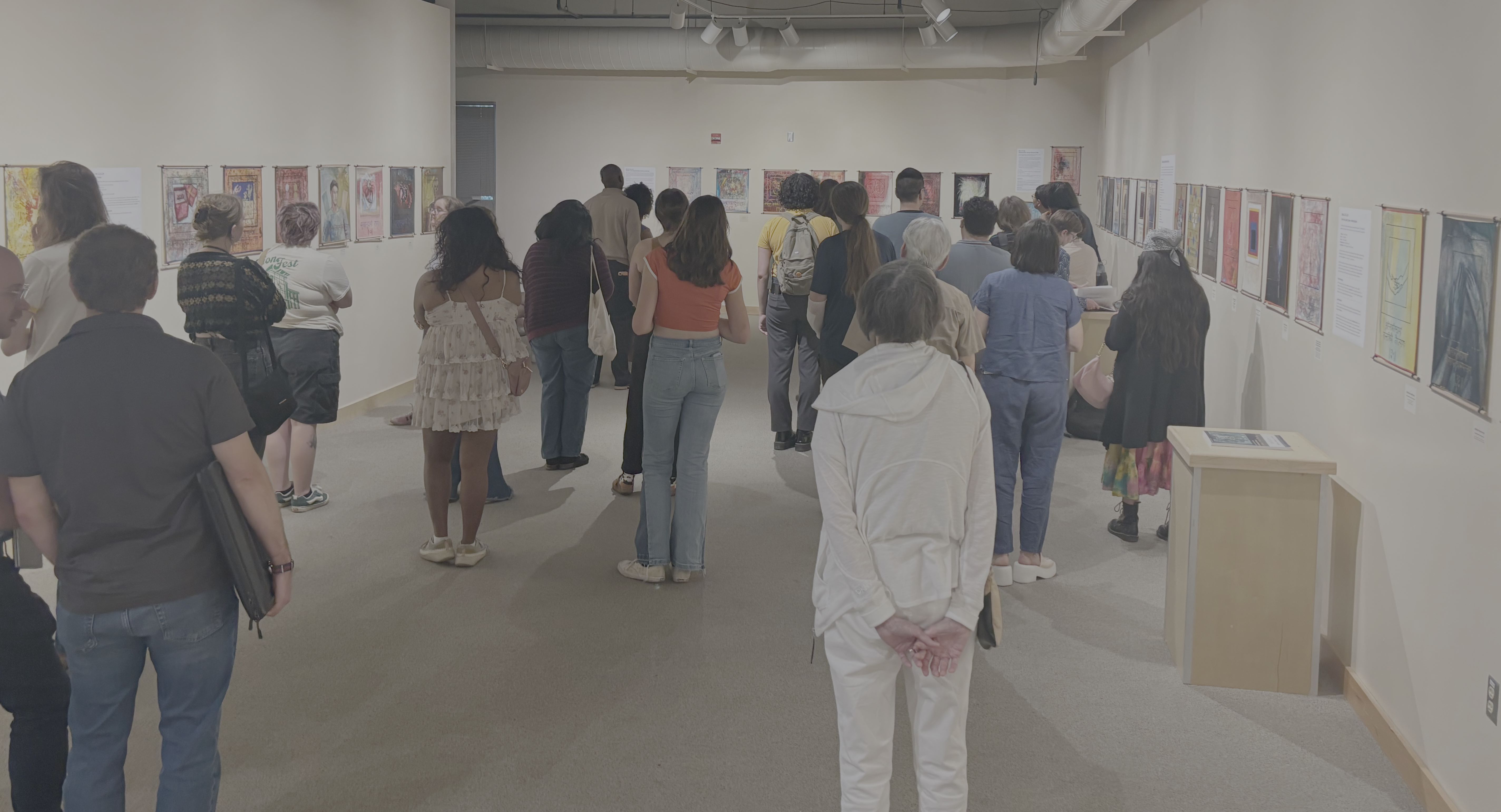 People stand in a gallery and look at art.