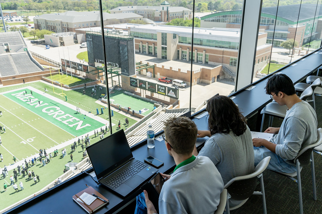 Students reporting in the coach's box of football field