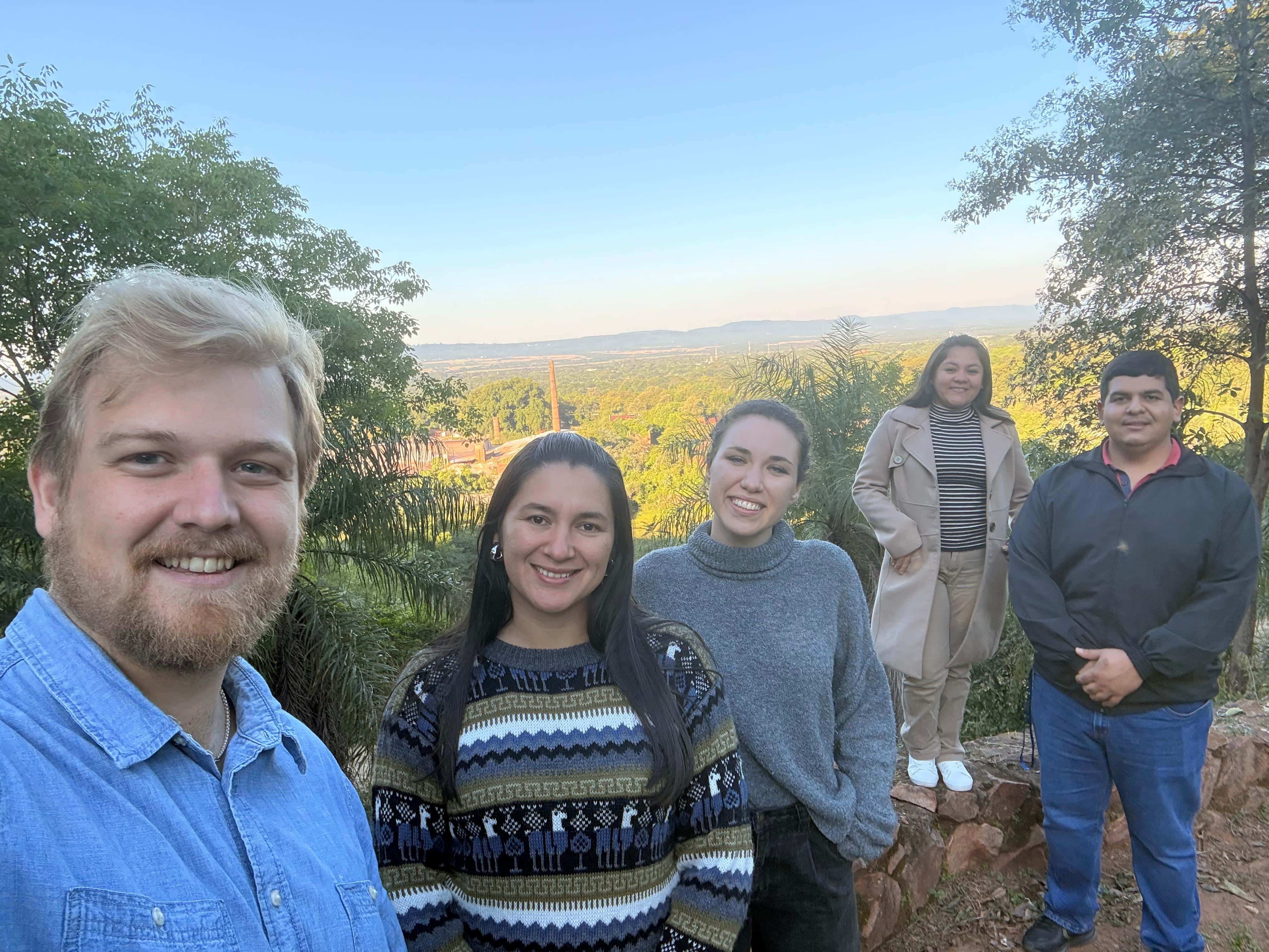 Delaney and others stand in front of a scenic overview