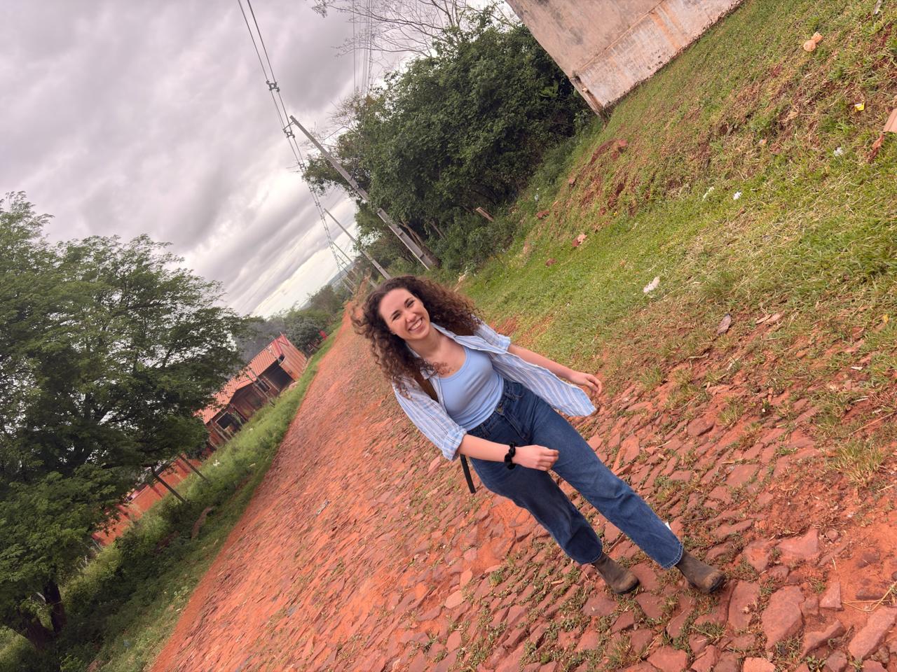 Delaney walks down a red stone path.