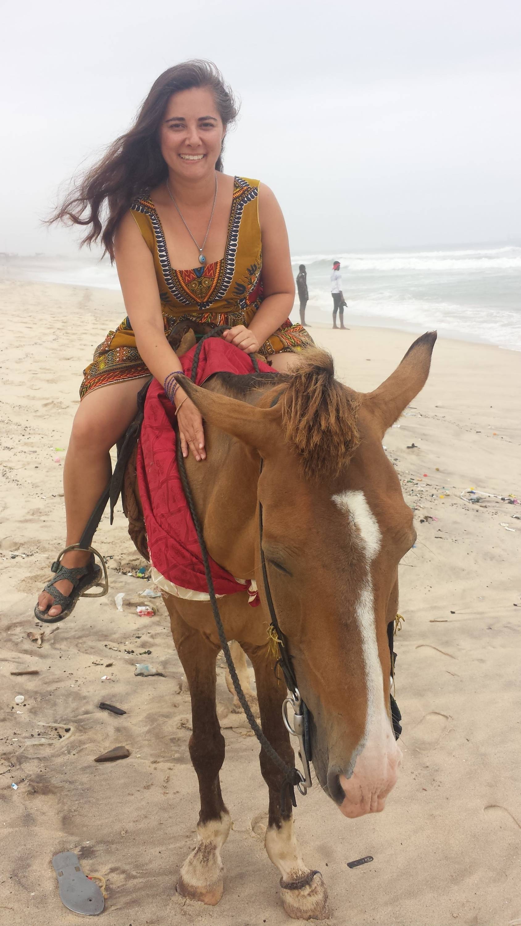 Joy Straley riding a horse on the beach.