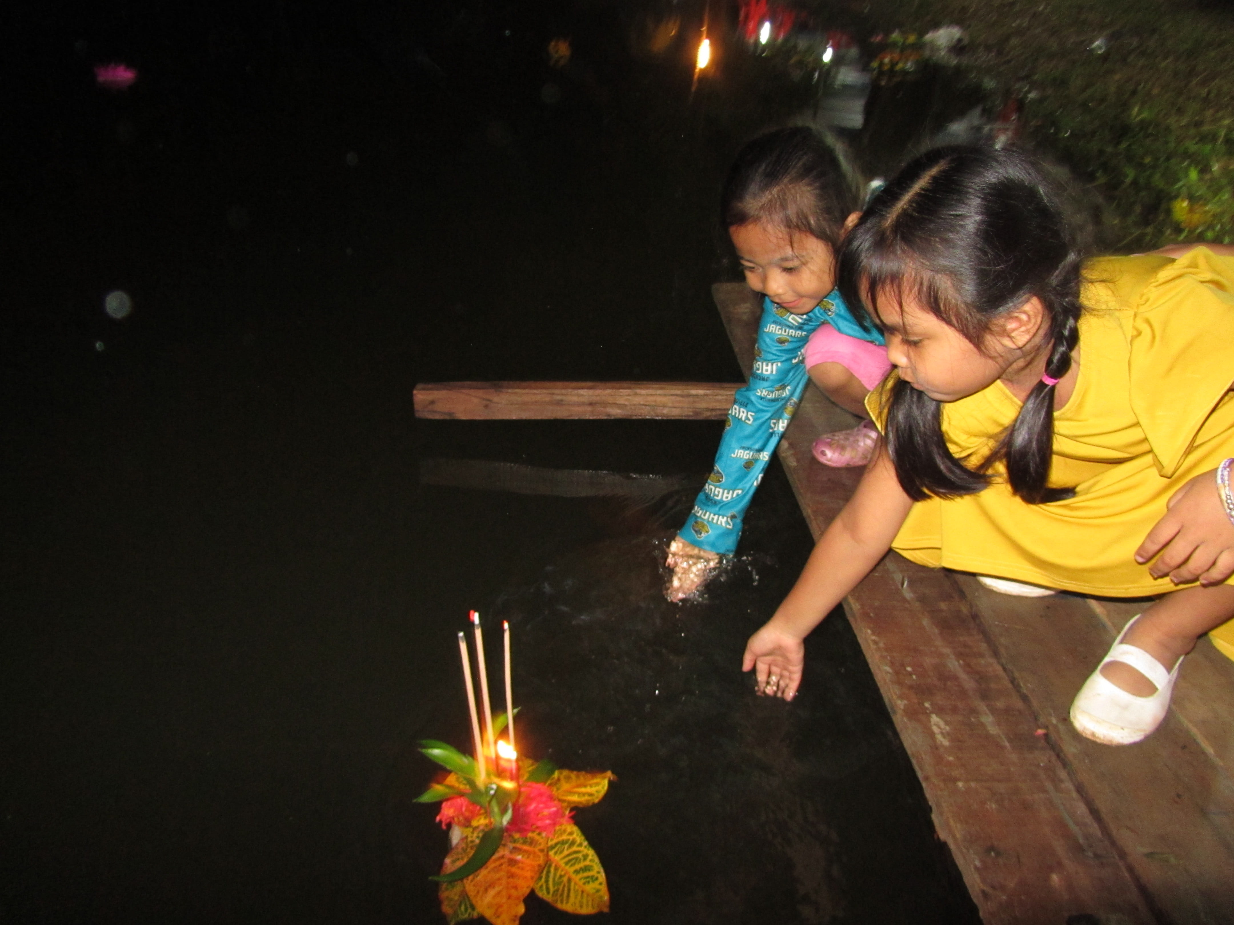 Children place their krathong during a local festival.